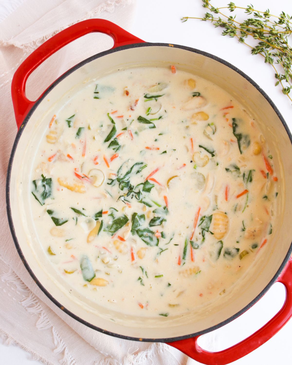 Creamy chicken gnocchi soup in a red Dutch oven.