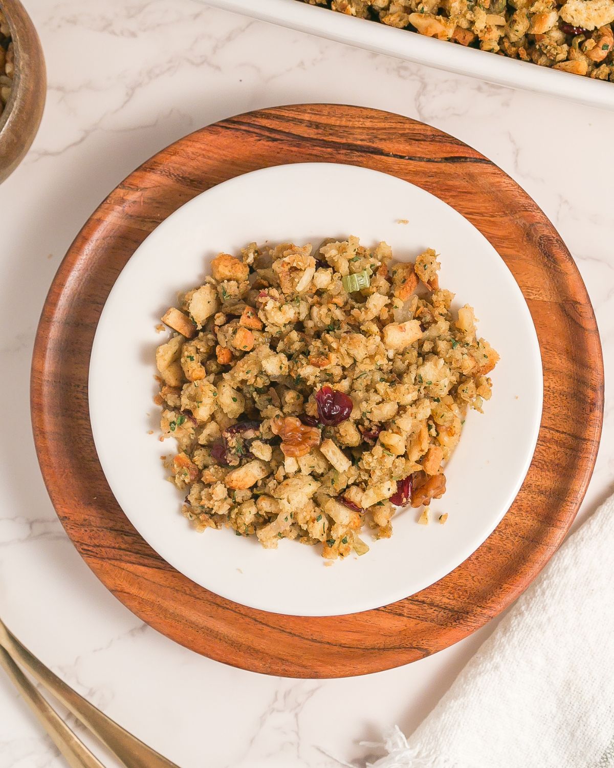A plate of stuffing made with stove top stuffing mix, vegetable broth, dried cranberries, and walnuts.