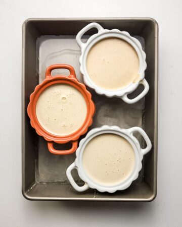 Ramekins with pumpkin custard to make creme Brulee.