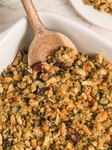 Stuffing made with stove top stuffing mix, walnuts, and cranberries in a casserole dish.