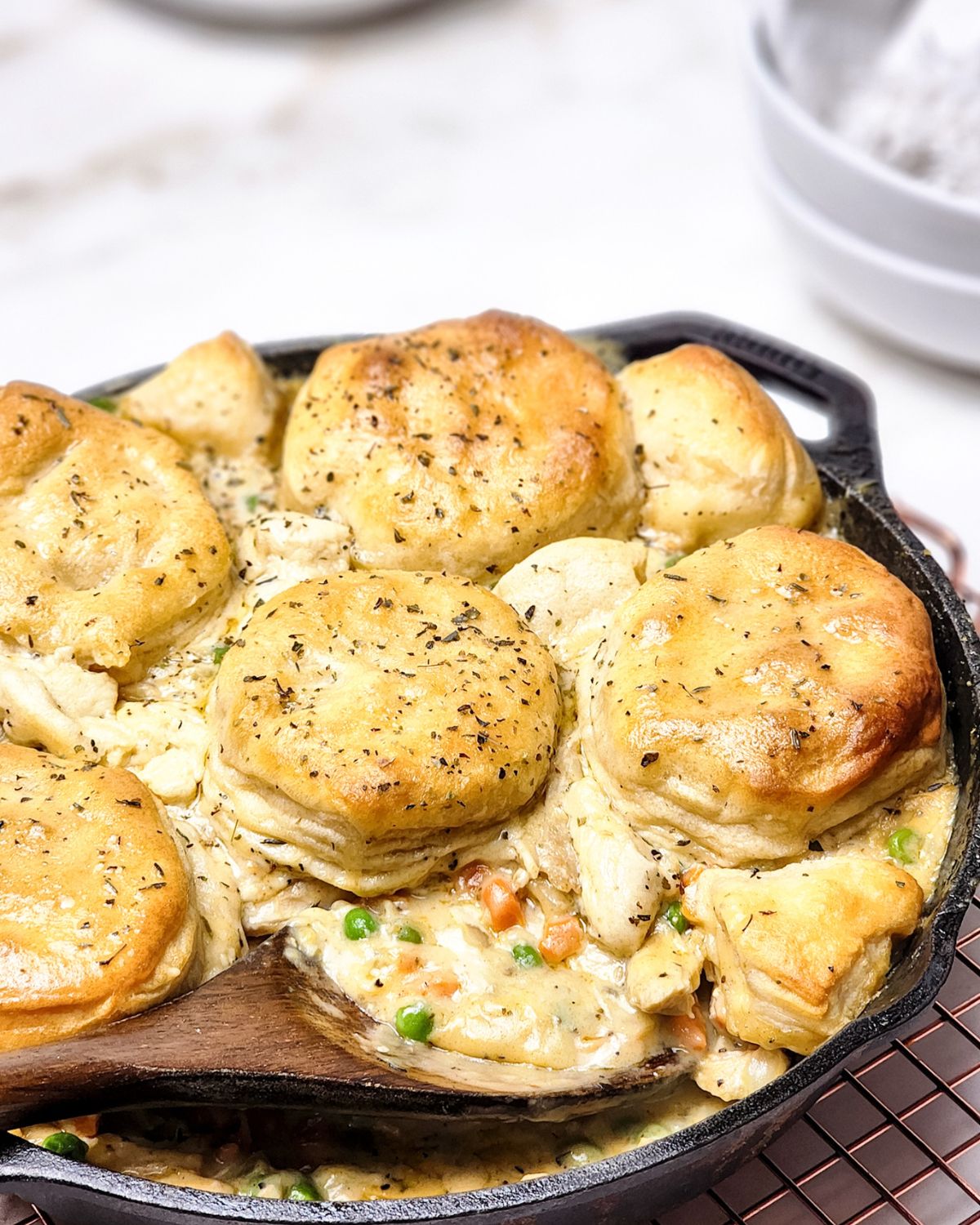 Biscuit topped chicken pot pie in a cast iron skillet.