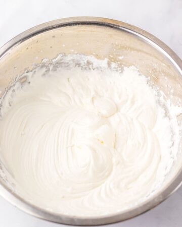 A mixing bowl with ingredients to make Christmas tree cake frosting. 