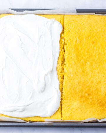 A sliced cake with frosting in the process of making christmas tree cakes. 