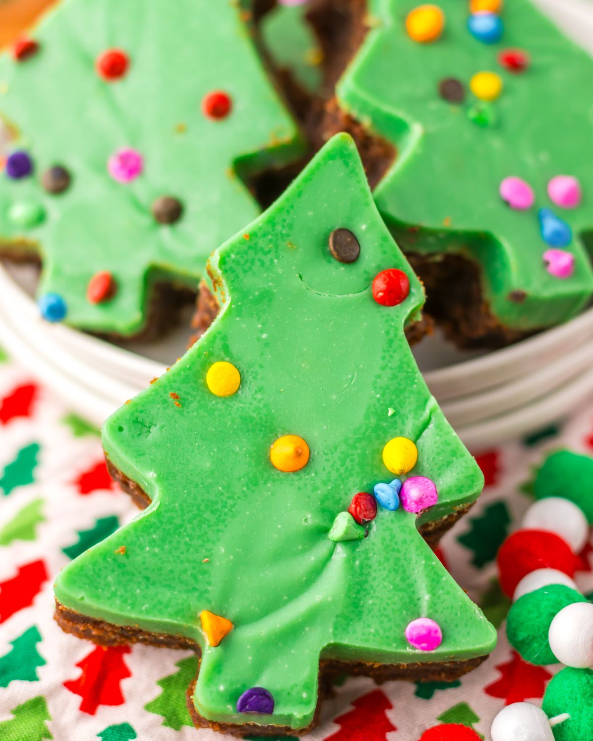 Cosmic Christmas Tree Brownies topped with a green ganache and sprinkles.