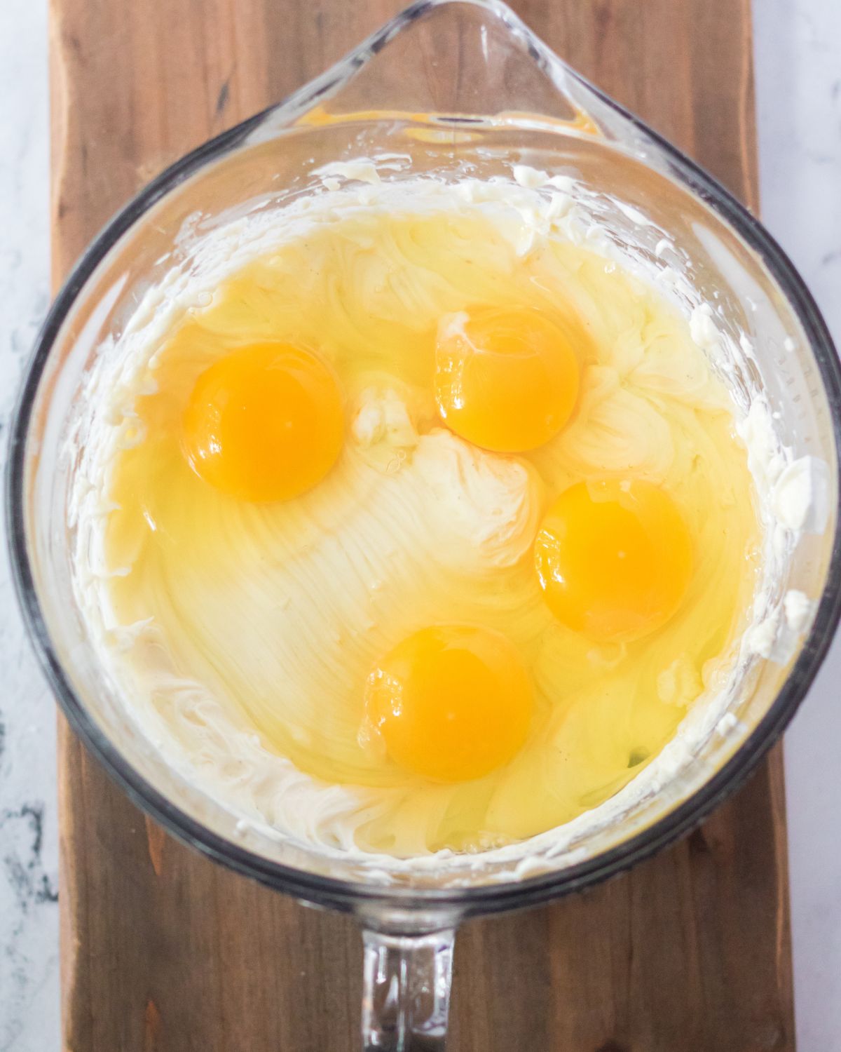 A glass measuring bowl with eggs to make Christmas cheesecake. 