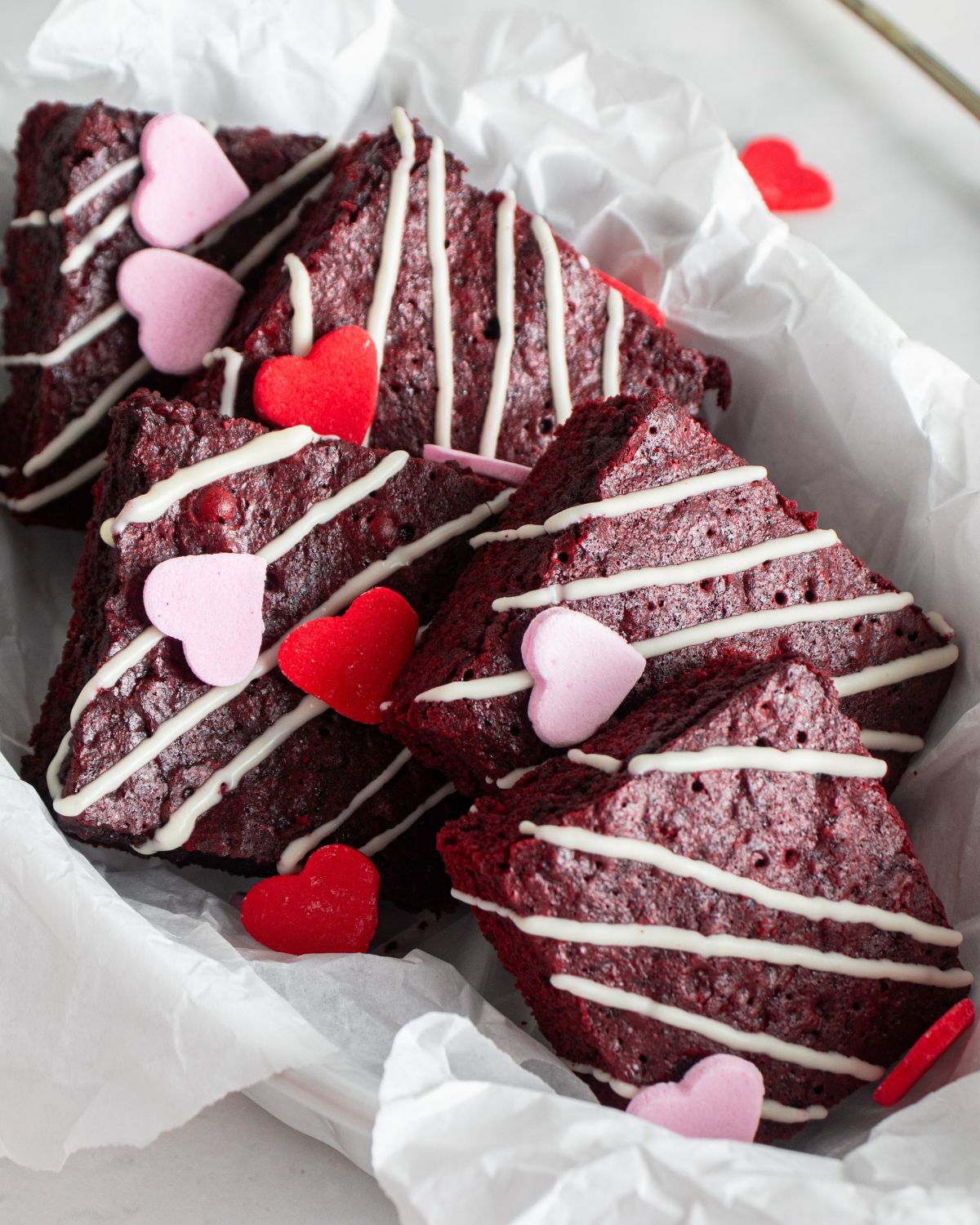 Red Velvet Brownies with a white chocolate drizzle and candy hearts for Valentines Day.