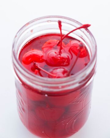 Cherries marinated in whiskey in a mason jar.
