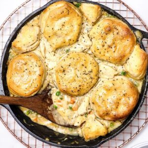 Chicken pot pie with biscuits in a cast iron pan.