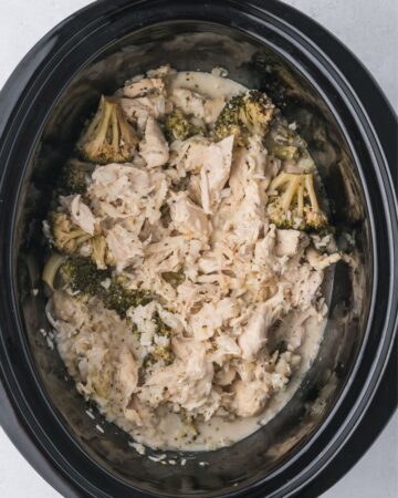 A slow cooker vessel with broccoli, chicken, and rice.