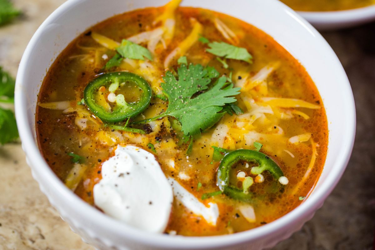 A bowl of enchilada soup made with chicken in the crockpot.
