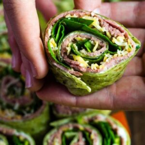 A roast beef tortilla rollup in a hand.