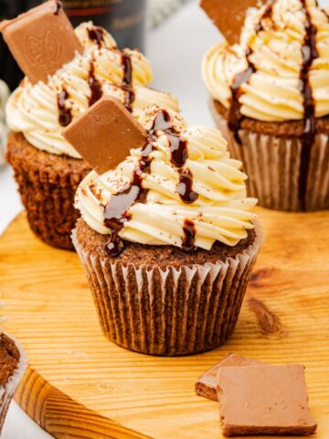 Baileys cupcakes on a wooden cutting board.