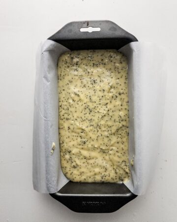 A loaf pan with batter to make a lemon poppy seed loaf.