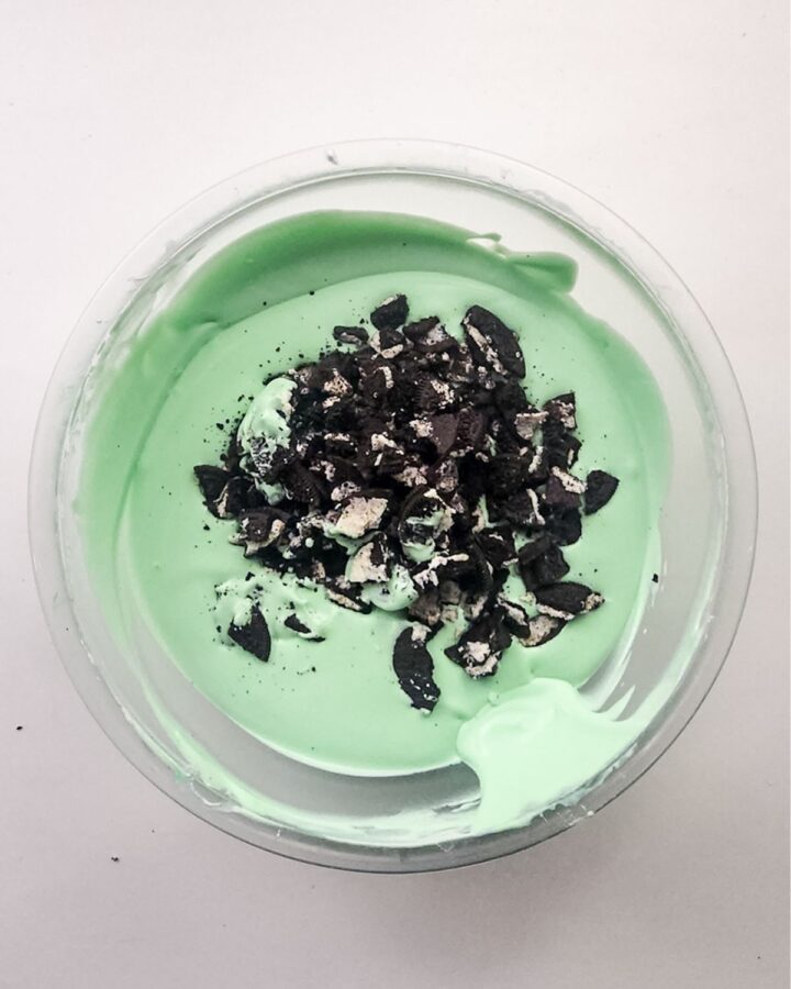 A glass mixing bowl with ingredients to make mint ice cream.