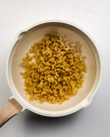 Cavatappi pasta cooking to make a pizza pasta casserole.
