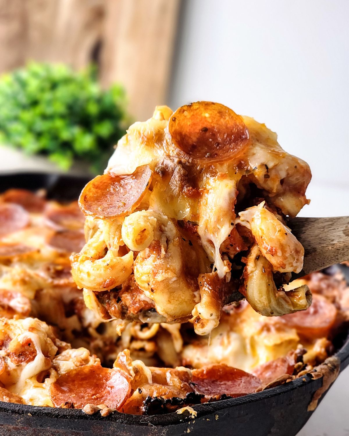 Pizza pasta in a cast iron pan that has been baked with pepperoni on top.