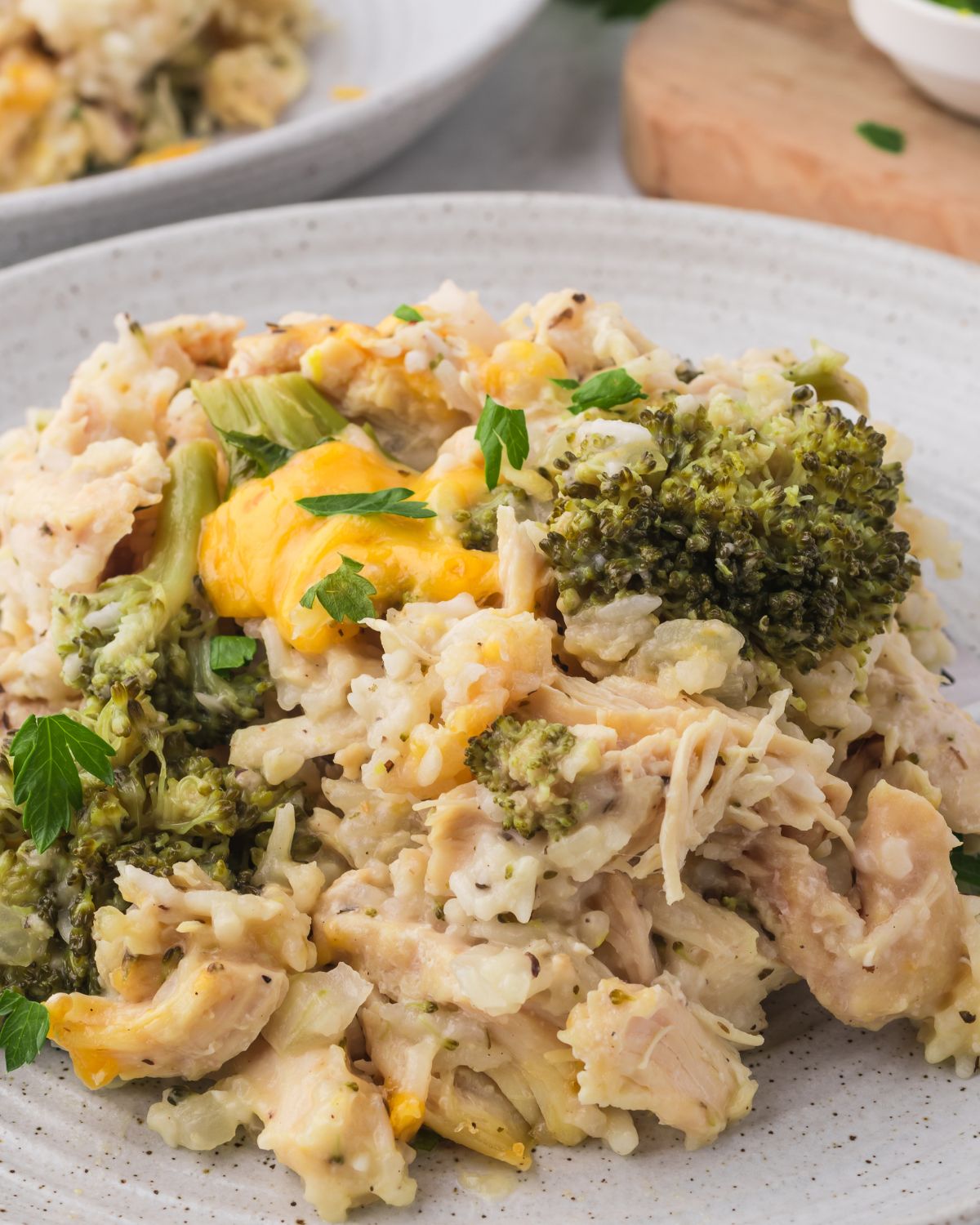 A white plate with chicken broccoli rice on a plate made in the slow cooker.
