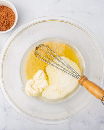 A glass bowl with wet ingredients to make Bailey's cupcakes. 