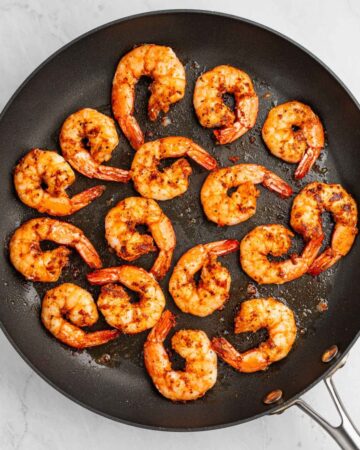 Cajun seasoned shrimp sauteed in a pan to make cajun shrimp pasta.