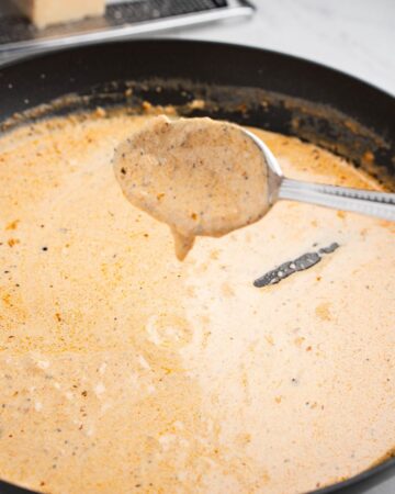 A saute pan with cajun cream sauce.