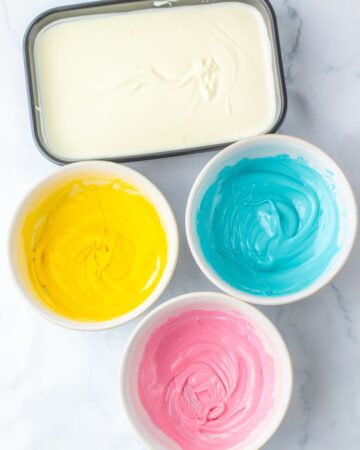 Melted candy melts and almond bark in bowls to make Easter saltine cracker toffee.