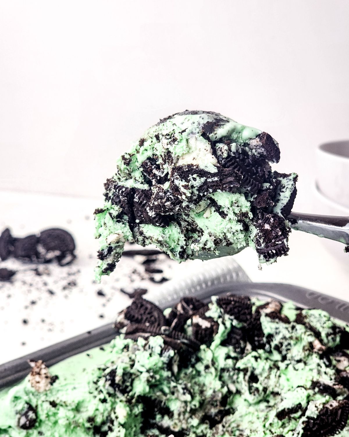 A big scoop of mint Oreo ice cream being scooped out of the