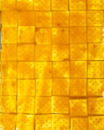 Saltine crackers on a tray topped with brown sugar to make saltine crack toffee.
