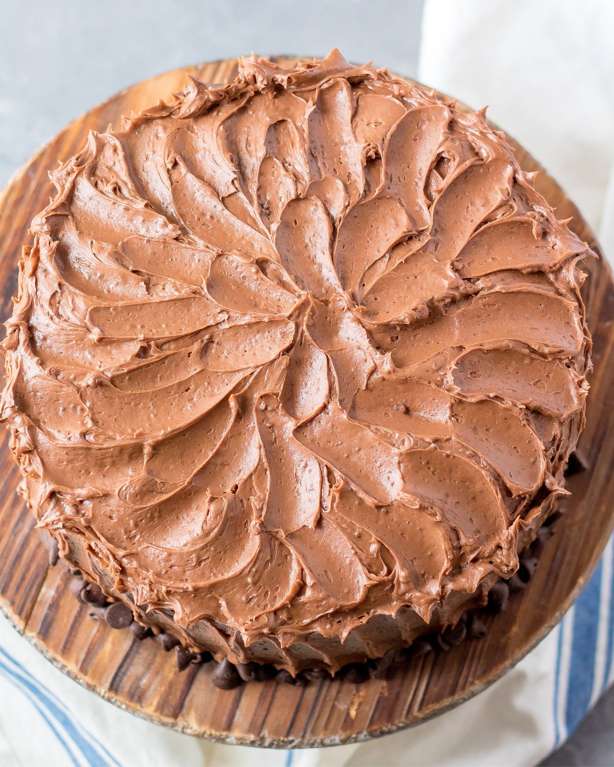 Homemade chocolate cake with chocolate frosting on a cake plate.