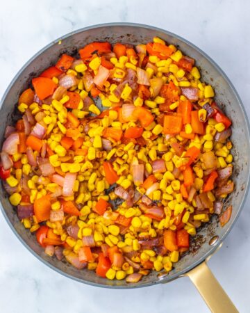 Mexican street corn vegetables charred in a saute pan for chicken salad.