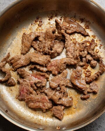 A saute pan with steak sauteed to make hibatchi steak.