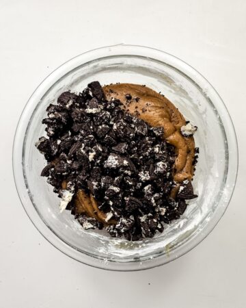 A glass mixing bowl with dough to make Oreo S'mores cookies