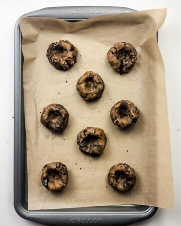 A baking sheet with parchment paper and the cookie doe for oreo smores cookies. 