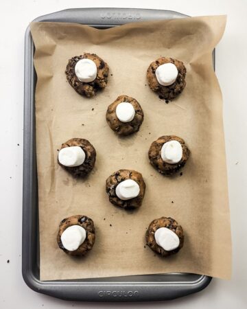 An Oreo Smores cookie with a marshmallow stuck in to the cookie to be baked. 