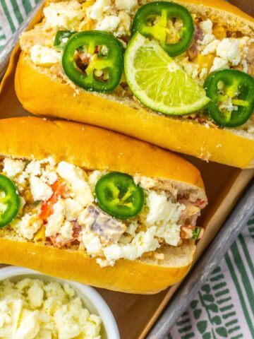 Mexican chicken salad in rolls topped with jalapeno and sliced limes.