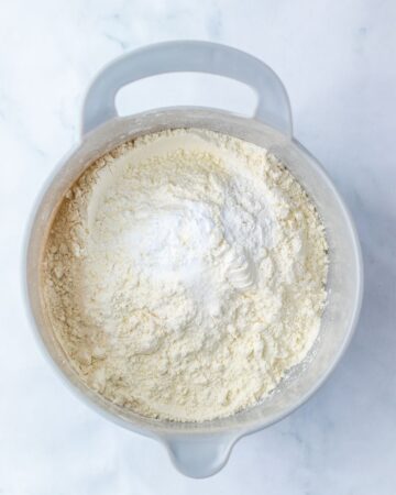 A bowl with flour, salt, and baking powder blending with a butter mixture to make a bomb pop cookie.