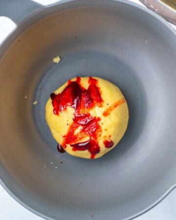 Cookie dough with red food coloring on the dough to make patriotic cookies.