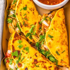 Chicken birria tacos on a tray.