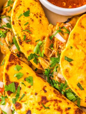 Chicken birria tacos on a tray.