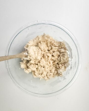 A glass bowl with a mixture of blended butter, flour, and sugar