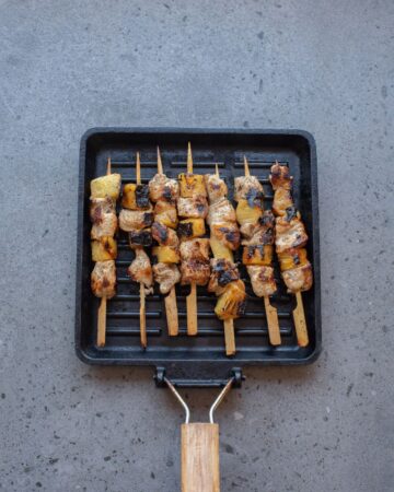 Pineapple Bang Bang Chicken Skewers on a grill pan.