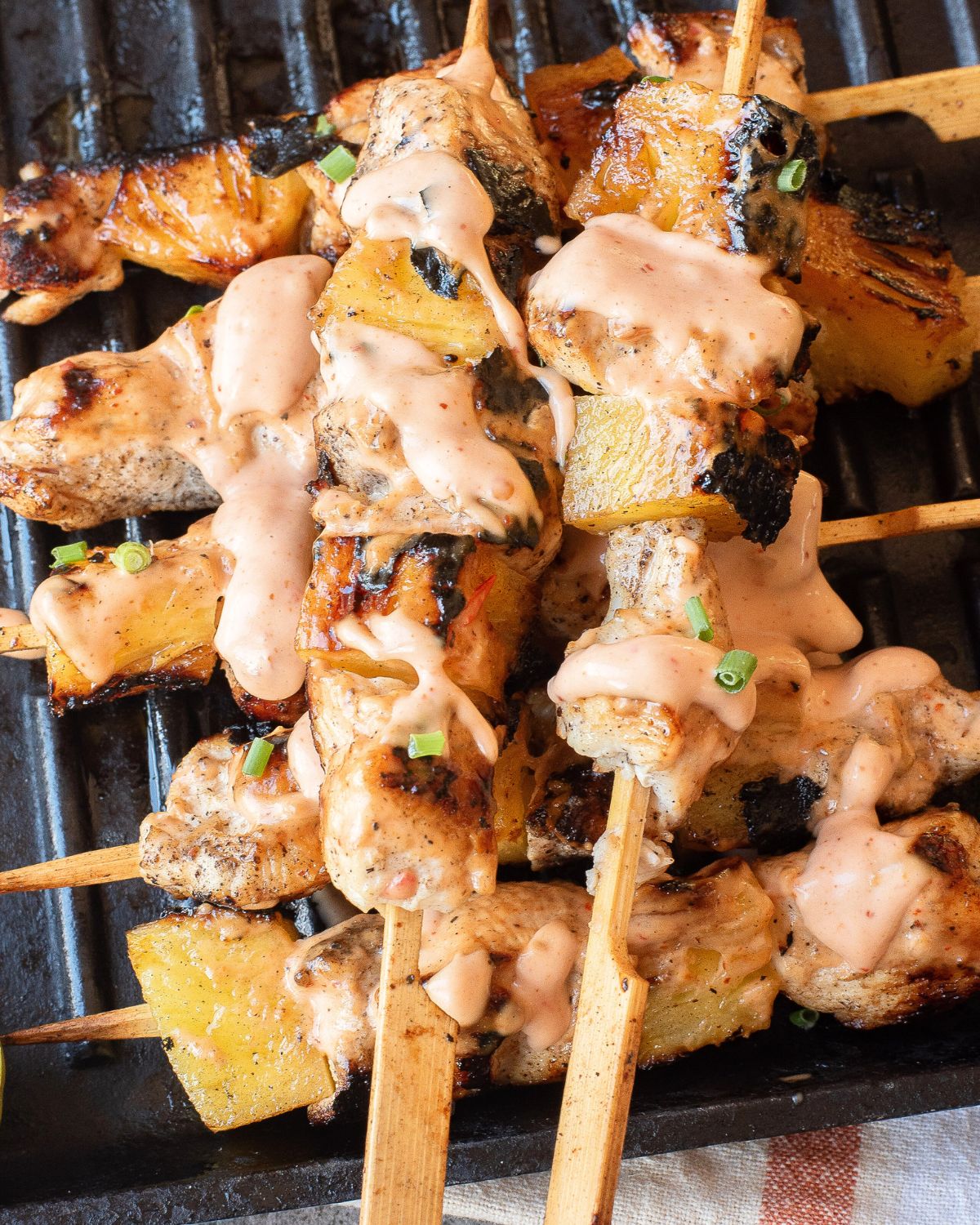 Bang Bang Chicken Skewers with pineapple on a grill pan. 