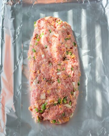Form the meatloaf ingredients into an oval shape on the baking pan.