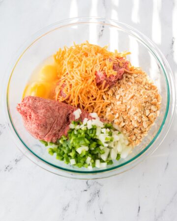 A glass bowl with ingredients to make a copycat cracker barrel meatloaf.