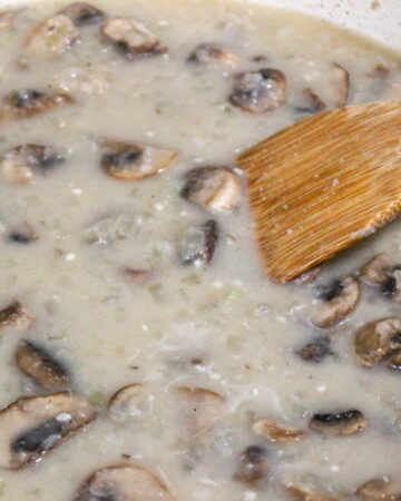 Mushrooms being cooked in a mushroom sauce for green bean casserole with chicken.