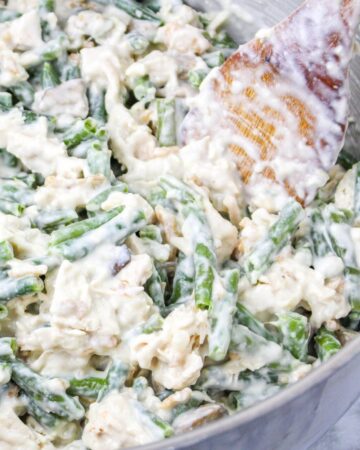 A bowl of green beans, chicken, mushrooms in a creamy sauce to make a chicken casserole.