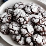 Chocolate crinkle cookies on a white platter.