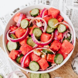 A cucumber watermelon salad with feta in a white bowl.