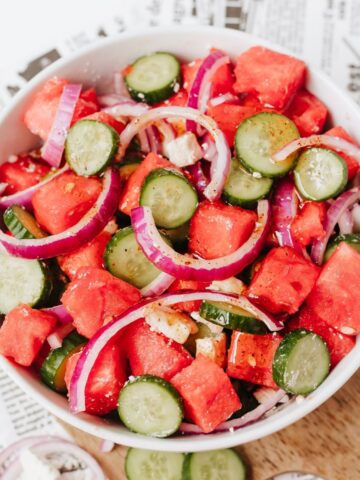 A cucumber watermelon salad with feta in a white bowl.