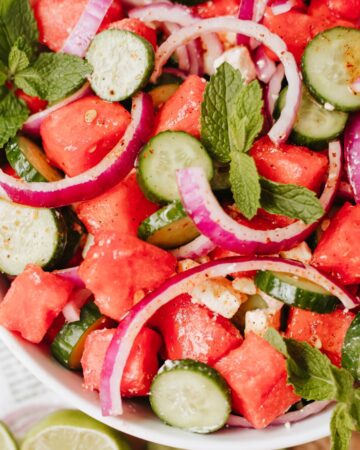 Cucumber, feta, onion salad in a bowl.