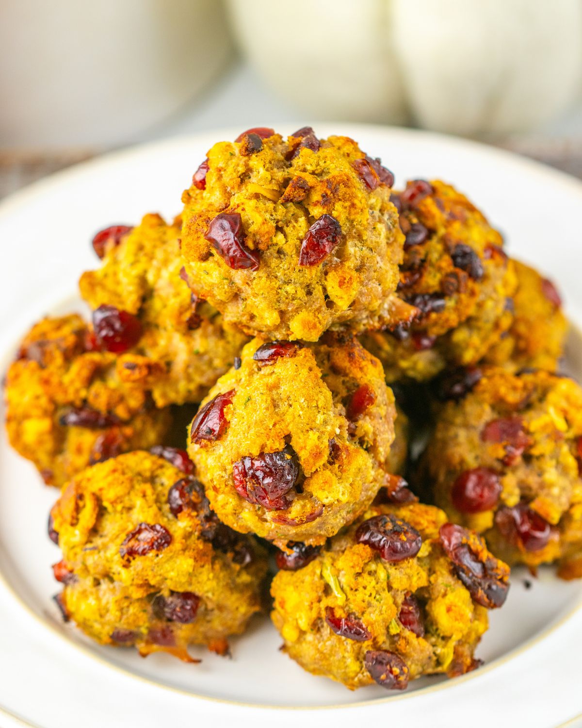 Turkey stuffing balls with cranberry on a white plate.